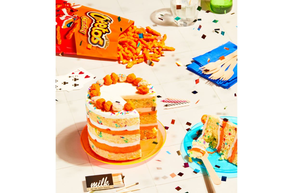 A birthday cake with Cheetos on top. 